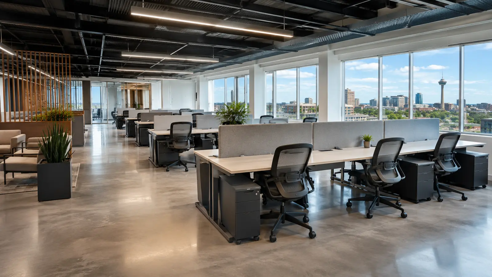 Modern commercial office workstations with ergonomic chairs and height-adjustable desks arranged in an open-plan layout inside a San Antonio office buildout, illustrating commercial furniture cost planning for a business relocation or tenant improvement project.